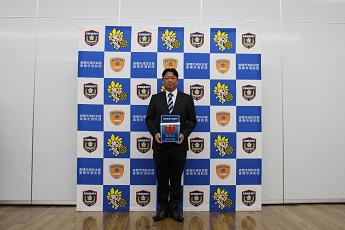 写真：表示証を持つ佐々木さん