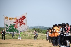 写真：コロナ撲滅と書かれた凧を掲揚する様子