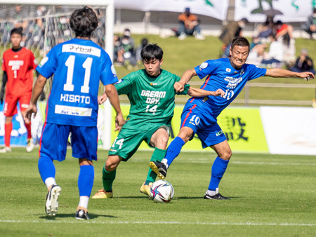 写真：ドリームマッチの様子（元日本代表と競り合う中学生）