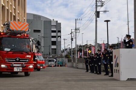 写真：巡回広報のために出発する消防車両を見送る消防職員ら