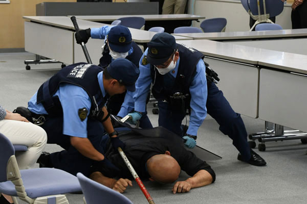 写真：訓練にて、不審者を3人の警察官で制圧している