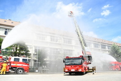 写真：消防ポンプ車で建物の消火をする様子