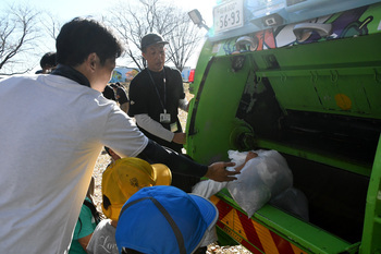 写真：集まったごみをパッカー車へ入れる参加者