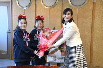 写真：市長からお祝いの花束を受け取る松村さん、澤さん