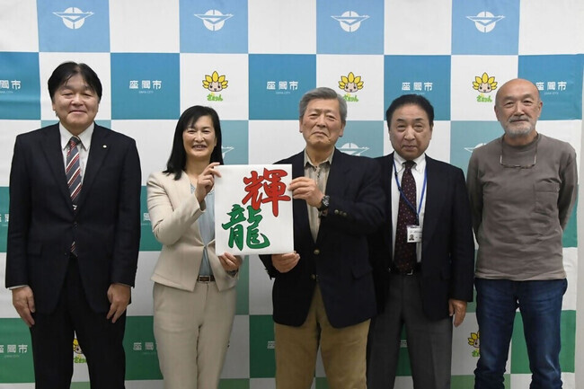 写真：決定した凧文字「輝龍」を持つ市長と凧文字選考委員