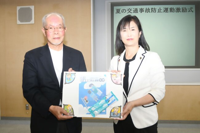 写真:市長(右)が市交通安全対策協議会代表のおいかわさん(左)に啓発物品を手交する様子
