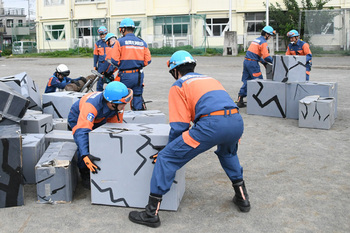 写真：倒壊した家屋から瓦礫を撤去する消防団