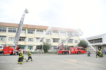 写真：消防ポンプ車で建物の消火をする様子