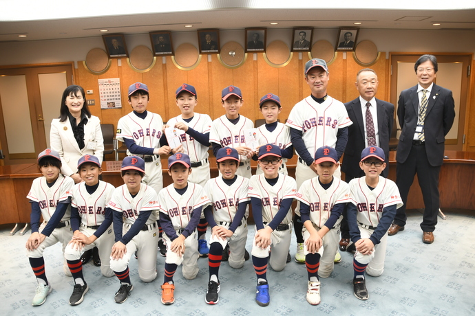 写真：集合写真（左から市長、選手の皆さん、よしだたつや監督、ひらうちけんじ代表、教育長）