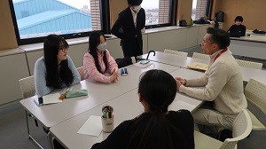 外国語指導助手（ALT）と、国際親善大使の3人の女性が会話をしている様子