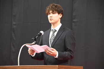 写真：壇上で実行委員長あいさつをするまちだじんたさん