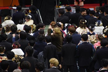 写真:スーツを着ている男性が抽選会に当選して喜んでいる様子