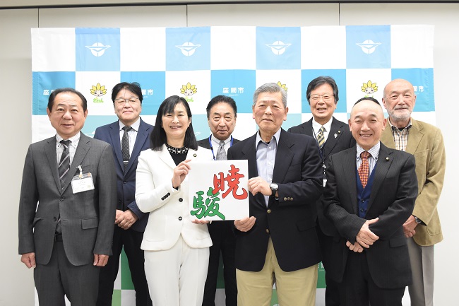写真：決定した凧文字「ぎょうしゅん」を持つ市長と凧文字選考委員