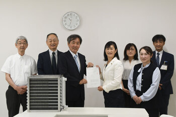 写真:市長とえんどうさんが交付状を持って並んでおり、その周りに三協空調システムの職員と市地域づくり部長が並んでいる様子