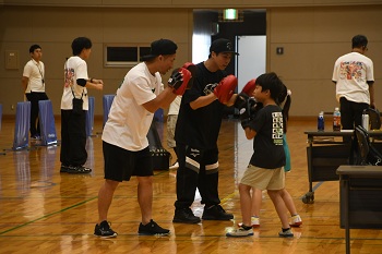写真:ミット打ちに参加するいのうえなおや選手といのうえたくま選手