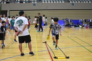 写真:ラダー体験の様子を見守るいのうえたくま選手
