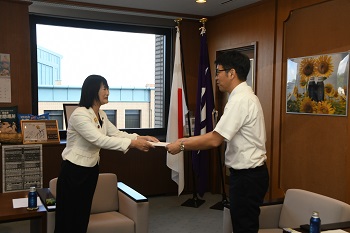 写真:市長がいとうさんに支援措置決定通知書を交付する様子