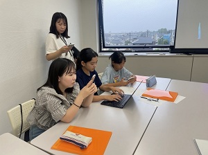 写真：参加者たちがスマホやパソコンを使ってシナリオを作っている様子