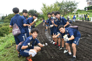 写真：種まきに参加している学生たちがピースしている様子