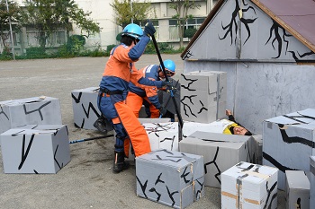 写真：倒壊した家屋から瓦礫を撤去する消防団